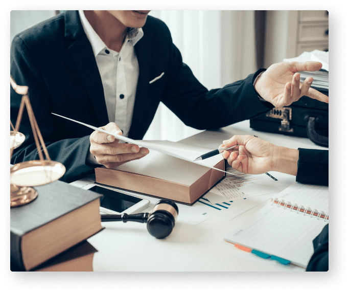 A couple of people sitting at a table with papers.