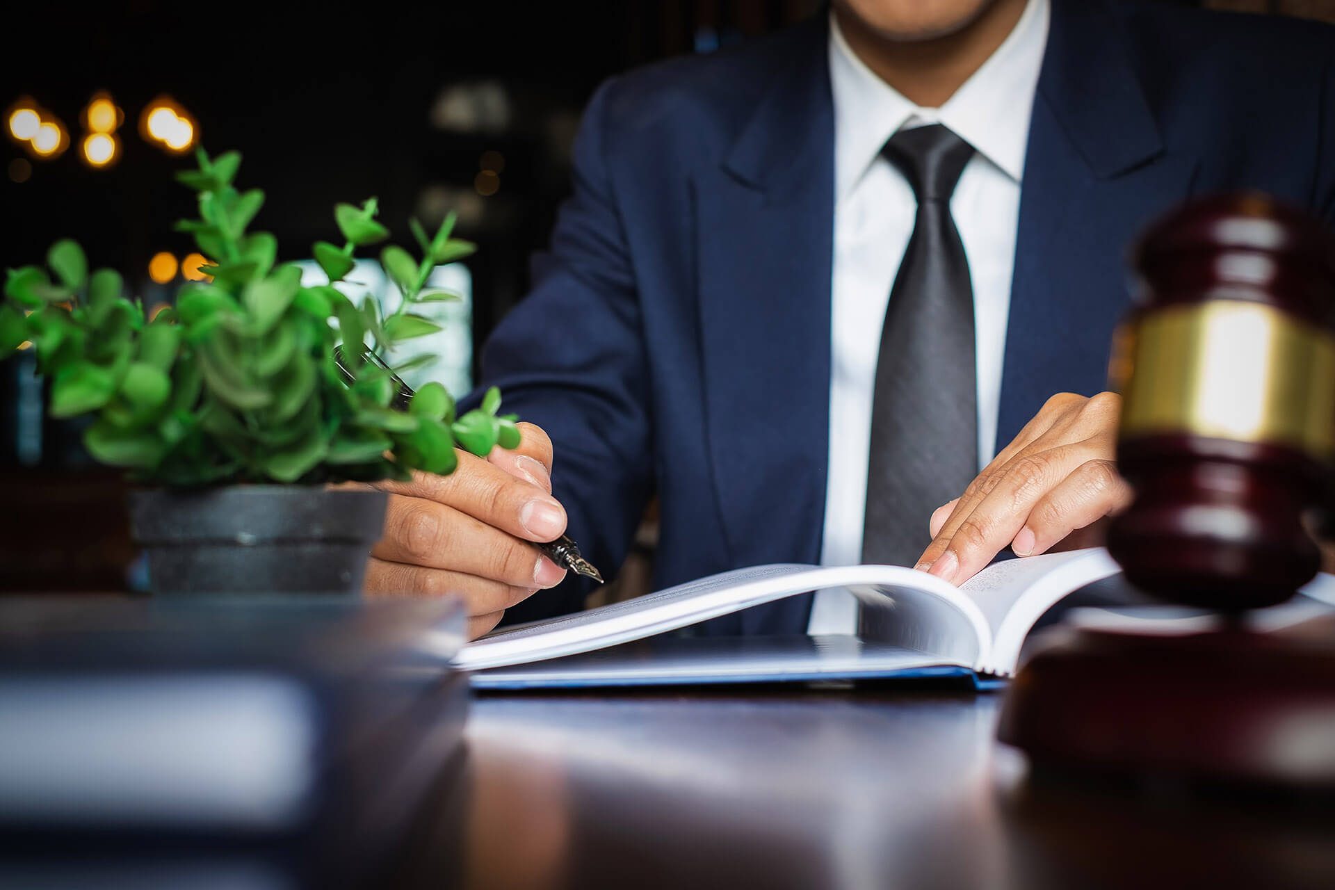 A man in a suit and tie writing on a book.