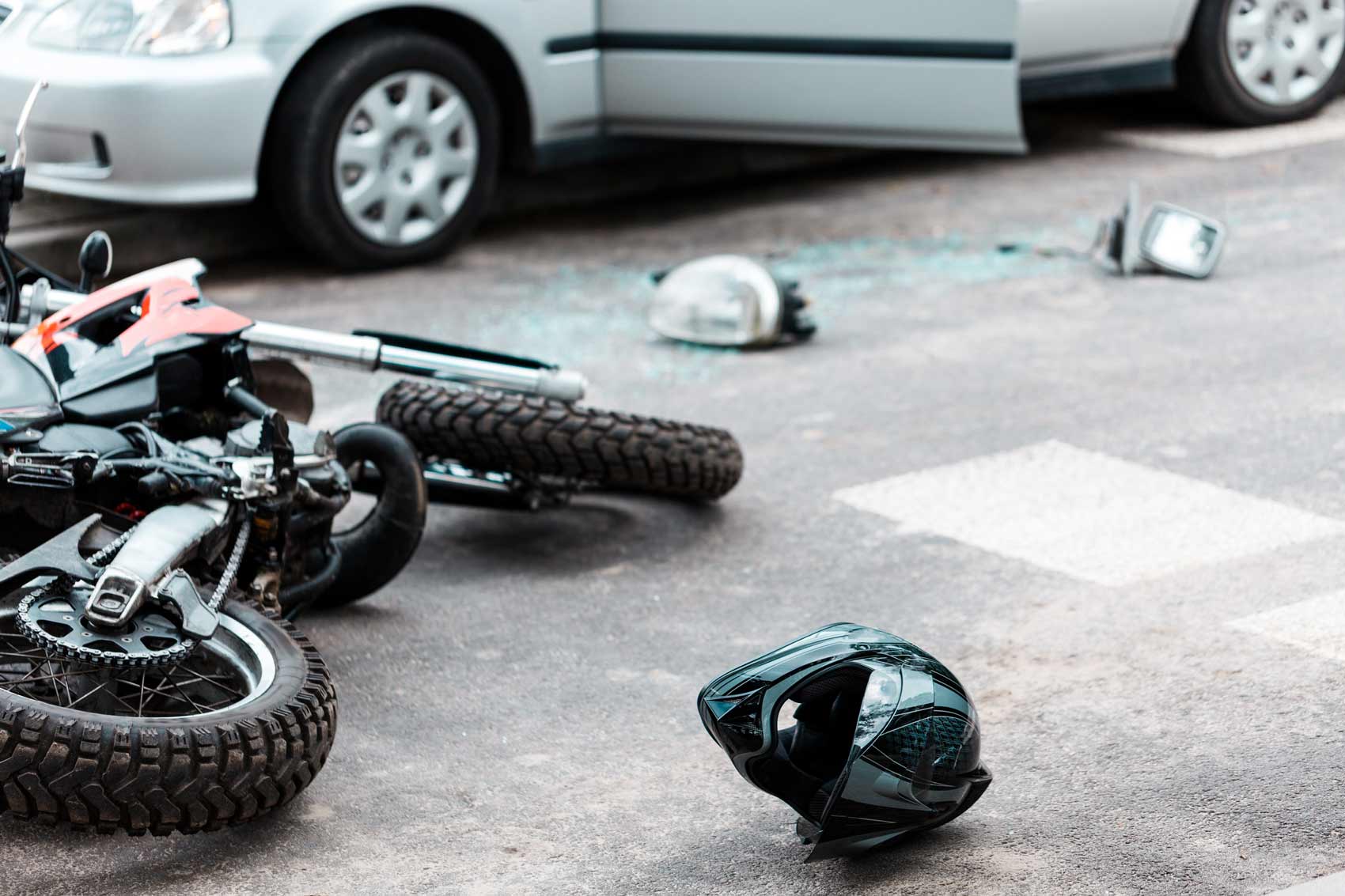 A motorcycle and helmet laying on the ground.