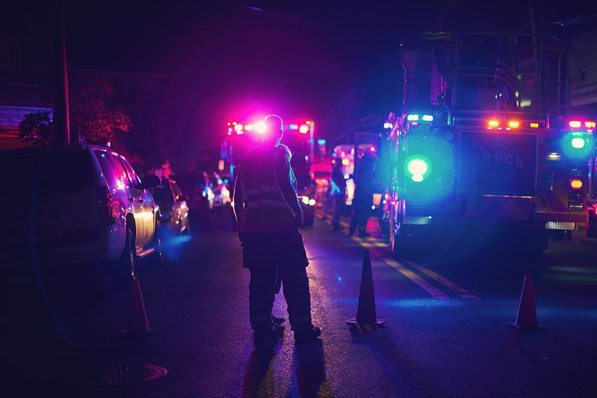 A police officer standing in front of a line of onlookers.