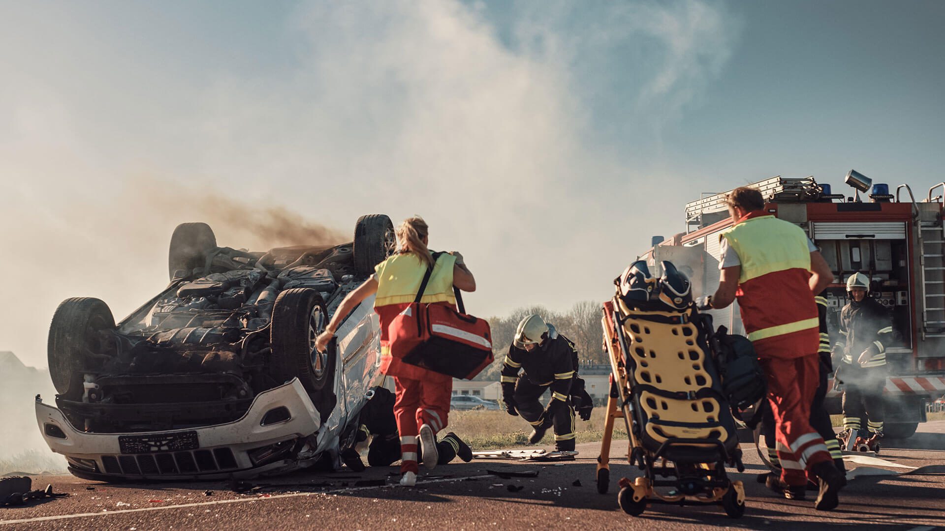 A group of people with luggage walking near some trash.