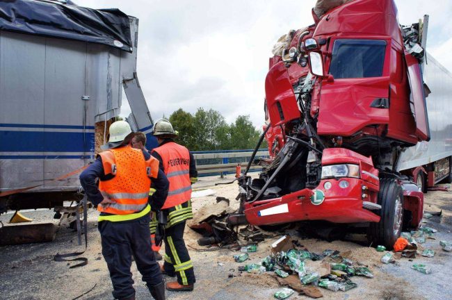 A red truck that has been smashed by another truck.